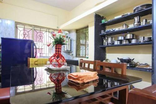 a kitchen with a table with a vase of flowers on it at Sudeep Bungalow in Alibaug