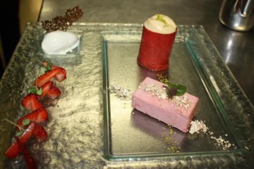 a plate with a dessert with strawberries on it at Hotel Krone Sihlbrugg in Sihlbrugg Dorf