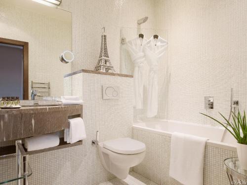 a bathroom with a toilet and a tub and a sink at B Montmartre in Paris
