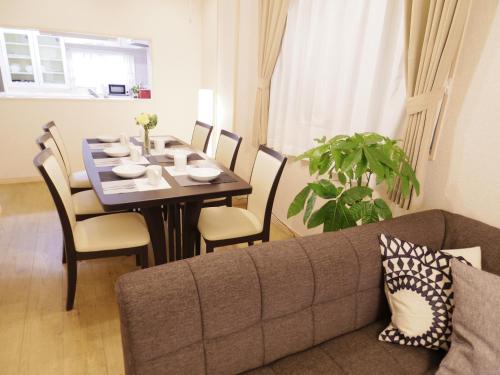 a living room with a table and a couch at Nao's Guesthouse 2 一軒家貸切 in Osaka