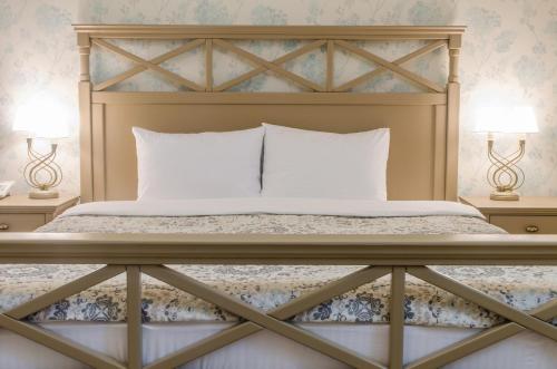 a bed with white pillows and two lamps on tables at Lepsza Садыба in Bila Tserkva