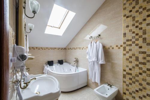 a bathroom with a tub and a toilet and a sink at Lepsza Садыба in Bila Tserkva