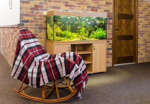 a chair with a blanket sitting in front of a fish tank at Lepsza Садыба in Bila Tserkva