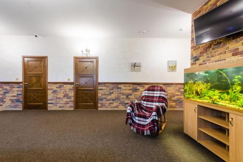 a large room with a fish tank and a chair at Lepsza Садыба in Bila Tserkva