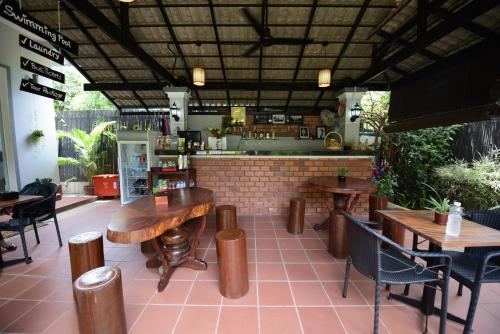 a restaurant with wooden tables and chairs and a bar at Nika's House in Siem Reap