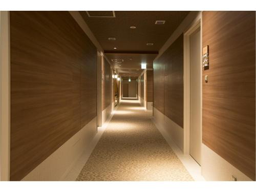 a long corridor with wooden walls and a long hallway at Wakkanai Grand Hotel in Wakkanai