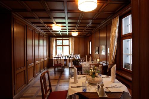 a dining room with tables and chairs and windows at Hotel Krone Sihlbrugg in Sihlbrugg Dorf