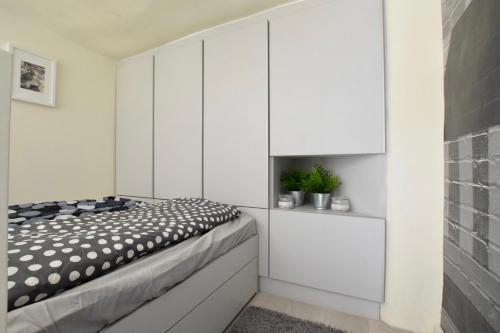 ブダペストにあるBudget Apartment by Hi5 - Krúdy streetの白いキャビネットとベッド付きのベッドルーム1室