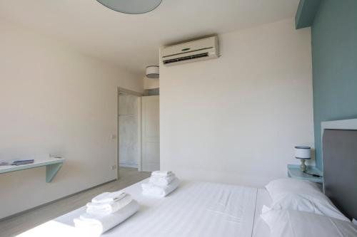 ein weißes Schlafzimmer mit Handtüchern auf dem Bett in der Unterkunft Borgo Guelfo VI in Florenz