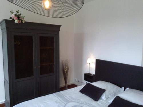 a bedroom with a bed with a black headboard at L'AURE BLEUE in Bayeux