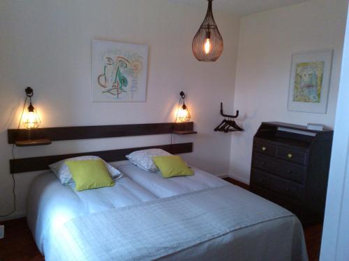 a bedroom with a bed and a dresser and lights at L'AURE BLEUE in Bayeux
