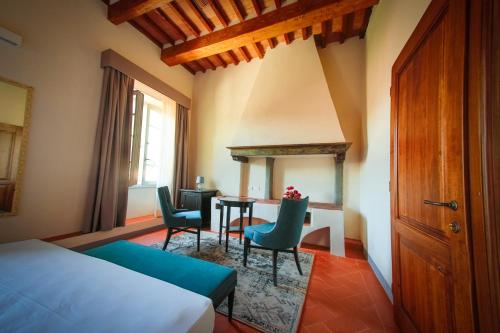 a bedroom with a bed and a table and chairs at Relais Villa Poschi in Pugnano