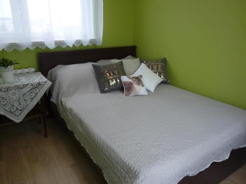 1 dormitorio con 1 cama con paredes verdes en Zamość przy Starówce en Zamość