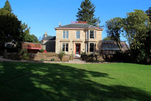a large white house with a large grass yard at Moorlands in Helensburgh
