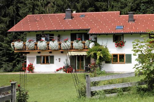 a white house with flower boxes on the balcony at Landhaus am Waldrand in Ramsau