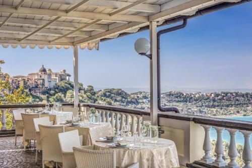 a restaurant with tables and chairs on a balcony at Hotel Castel Vecchio in Castel Gandolfo
