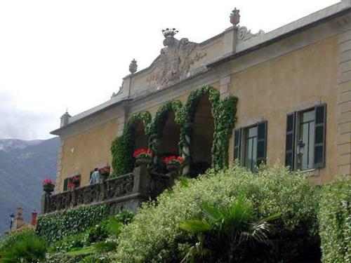 a building with flowers and plants on a balcony at Hotel Riviera in Griante Cadenabbia