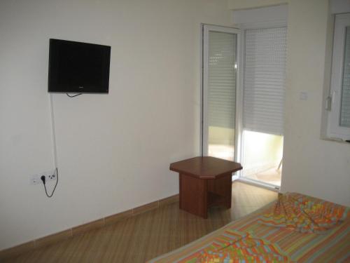 a bedroom with a bed and a tv on the wall at Guest House Vila Mimoza in Ulcinj