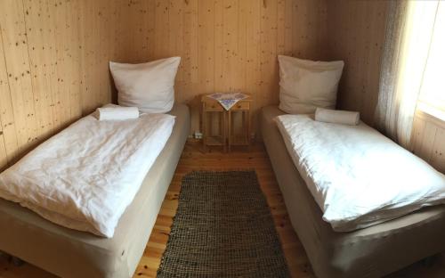 two twin beds in a room with a table at Lofoten Fishing in Å