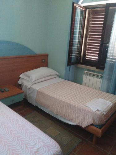 a bedroom with two beds and a window at Regina di cuori in LʼAquila