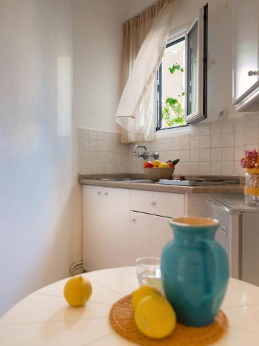 a kitchen with a blue vase and lemons on a table at Melissa Apartments, Studios & Suites in Malia