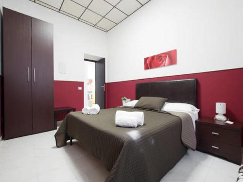 ローマにあるLa Lupa in Trastevereの赤い壁のベッドルーム1室(ベッド1台付)