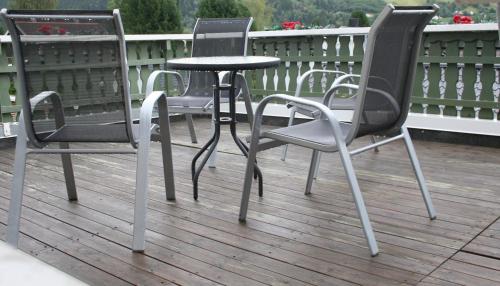 a group of chairs and a table on a deck at Vertshuset Fannarheimr - Bed &Breakfast in Fannrem