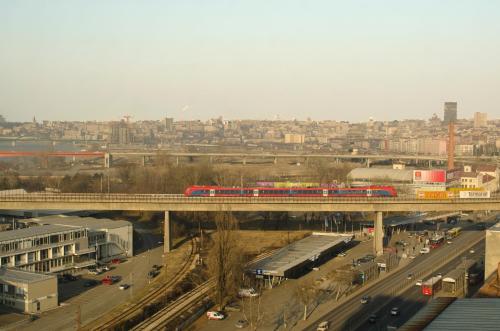 a train on a bridge over a highway at Nikola's Apartment in Belgrade