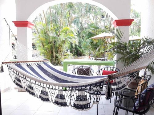 a hammock in a patio with a table and chairs at Hotel Ciudad Blanca in Copan Ruinas