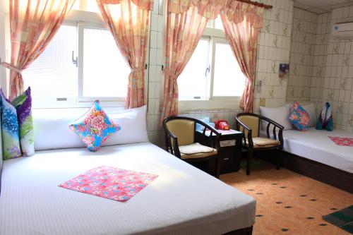 a bedroom with a bed, desk, chair and window at Hsin Hsin Hotel in Miaoli