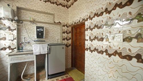 eine Küche mit einem Kühlschrank und einer Wand in der Unterkunft Pushkar Cooking Art and Home Stay in Pushkar