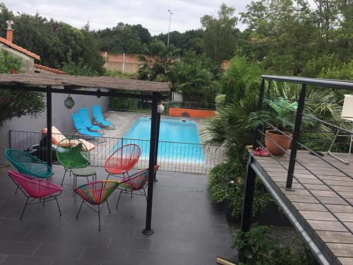 patio z krzesłami i basenem w obiekcie Maison (villa) de charme avec piscine w mieście Carbon-Blanc