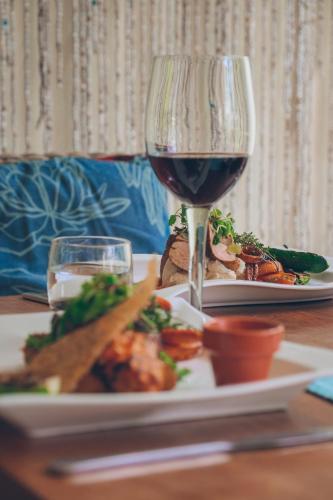 a glass of red wine next to a plate of food at Latitude 15 Degrees in Lusaka