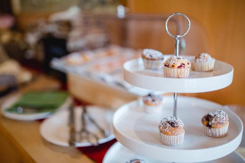 a three tiered display of cupcakes with sprinkles on them at Ratscher Landhaus in Ratsch an der Weinstraße