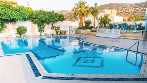 a swimming pool with a pool table and chairs at Melissa Apartments in Malia