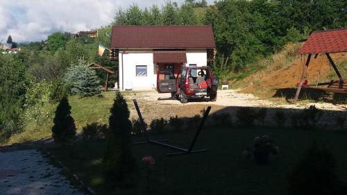 a red truck parked in front of a house at Cabana 7 Brazi in Poiana Mărului