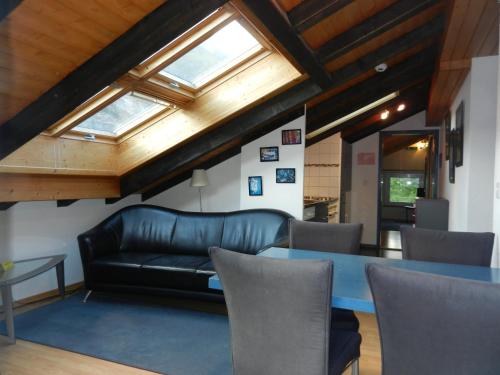 a living room with a leather couch and a table at Artist Apartments & Hotel Garni in Zermatt