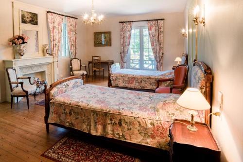ブーヴロン・アン・オージュにあるManoir de Sensのベッドルーム1室(ベッド2台、暖炉付)