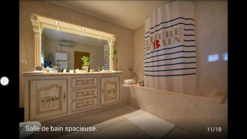 une salle de bain avec une baignoire et un grand miroir dans l'établissement SUITE-Junior -Villa HÉLÈNE - Montpellier Sud - aéroport- PISCINE Privée-2mn des plages, à Pérols