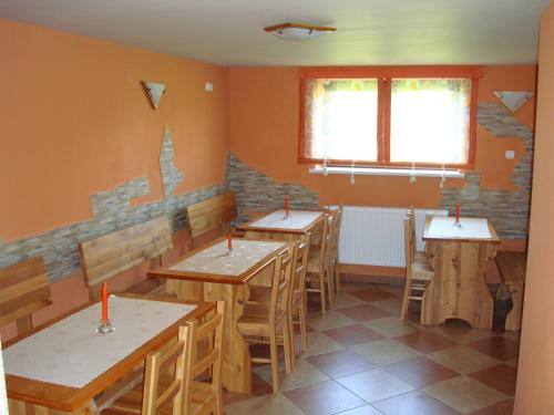 a row of tables and chairs in a room with orange walls at Agroturystyka Jędruś - Nocując u nas otrzymasz 20 procent zniżki na termy Gorący Potok i Szaflary in Szaflary