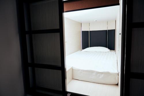 Hotel Kapsula في أستانا: غرفة نوم مع سرير في مرآة