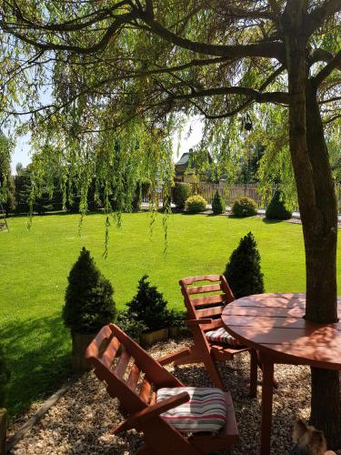 a picnic table and chairs under a tree in a yard at Pokoje Pod Bocianem in Chochołów