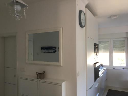 uma cozinha branca com um relógio na parede em Trogir Penthouse IVY em Trogir