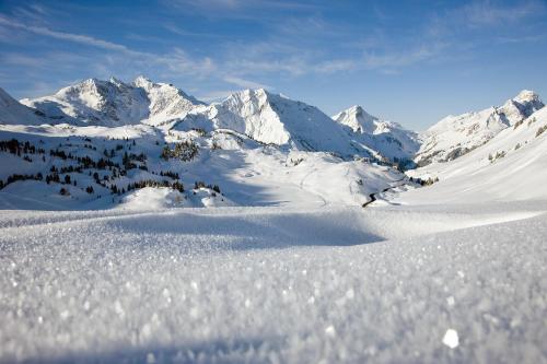 a snow covered mountain range with mountains in the background at Hotel Adler in Warth am Arlberg