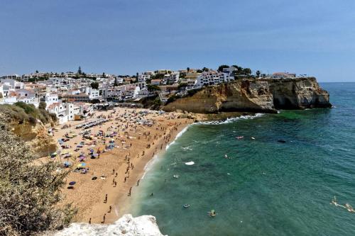 un groupe de personnes sur une plage près de l'océan dans l'établissement Oasis Praia Carvoeiro Bay, à Carvoeiro