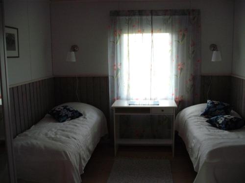 Ahkula House في Lemmenjoki: سريرين في غرفة صغيرة مع نافذة
