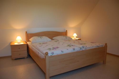 a bedroom with a wooden bed with two night stands at Heu-Ferienhof Altkamp in Putbus