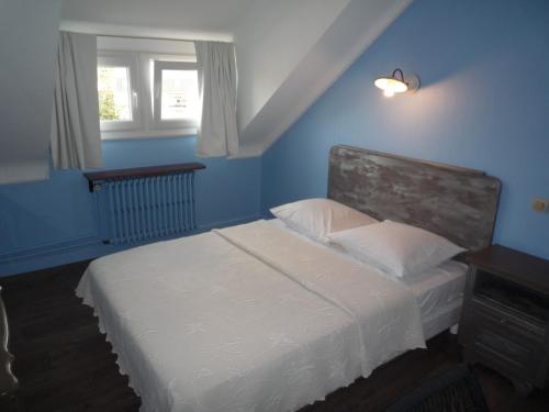 a bedroom with a white bed and a window at Hotel Du Centre in Hagondange