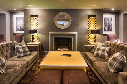 a living room with two couches and a fireplace at Auchrannie Resort in Brodick