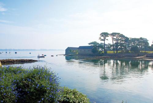 a body of water with people in a boat in it at Hotêl & Spa Du Parc Fétan in Larmor-Baden